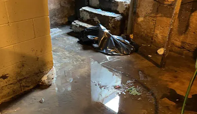 Storm water standing on a basement floor beside the stairs